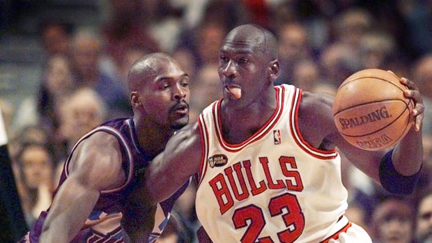 June 12, 1998; Chicago, IL, USA; Chicago Bulls guard Michael Jordan goes up against Utah Jazz player Bryon Russell in 1998 NBA Finals.